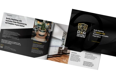 An open brochure displays images of modern interiors, text, and the R&M Shopfitting Construction logo. The design uses black, white, and gold accents, highlighting quality Australian-made manufacturing and project control.