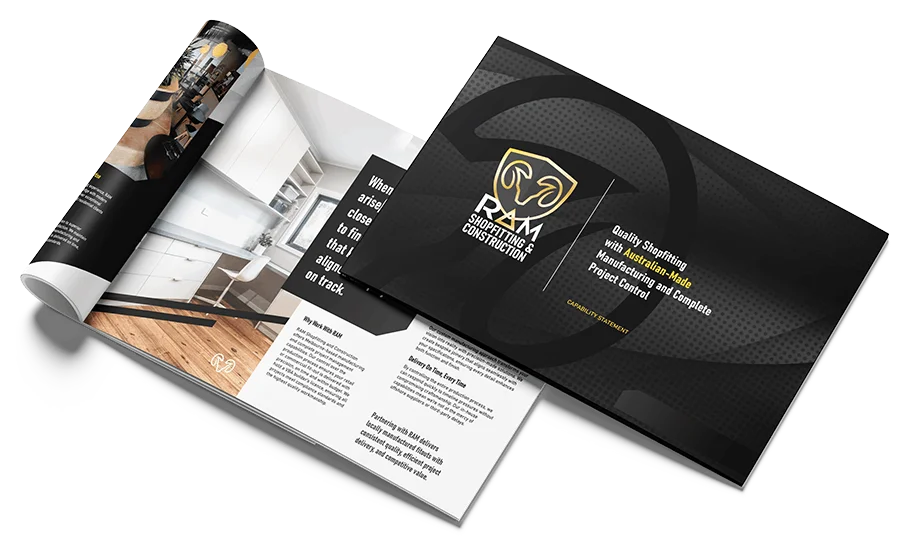 Two brochures are displayed; one is open showing modern white kitchen designs, text, and images, while the other is closed with a black cover featuring the PZM Contracting & Construction logo and project management text.